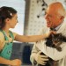 senior male veterinarian holding cat for child to pet