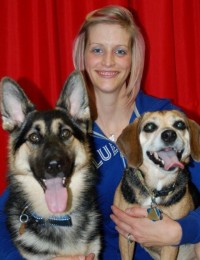 woman holding german shepherd and beagle